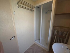 Ein Badezimmer mit Dusche, Toilette und Handtuchhalter.