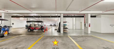 Un parking à plusieurs niveaux, avec des places de stationnement délimitées et un véhicule rouge au premier plan.