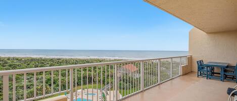 A balcony with a pool, outdoor furniture, and a view of the ocean.
