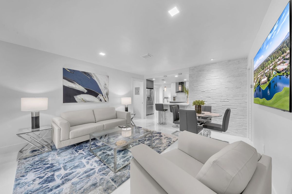 A modern living room with a sofa, coffee table, and artwork on the walls.