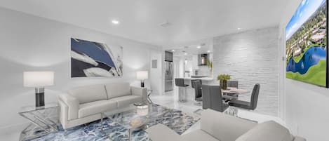 A modern living room with a sofa, coffee table, and artwork on the walls.