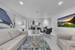 A modern living room with a sofa, coffee table, and artwork.