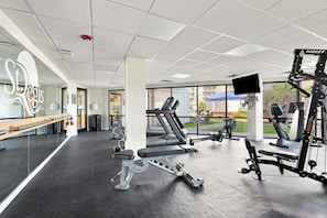 A gym with treadmills, weight machines, and a large mirror. - Discover Coastal Luxury at “Sea Breeze Bliss” (North Topsail Beach)