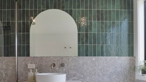 Ein Badezimmer mit einer freistehenden Badewanne, einem Waschtisch und einem Spiegel darüber.