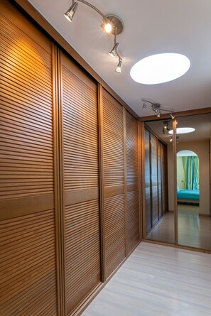 A corridor with wooden panel walls, a mirrored wall, and recessed ceiling lighting. - Villa Celeste  A Serene Holiday Getaway (Adeje)