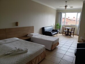 Habitación de hotel con dos camas, un sofá, una mesa y una silla.