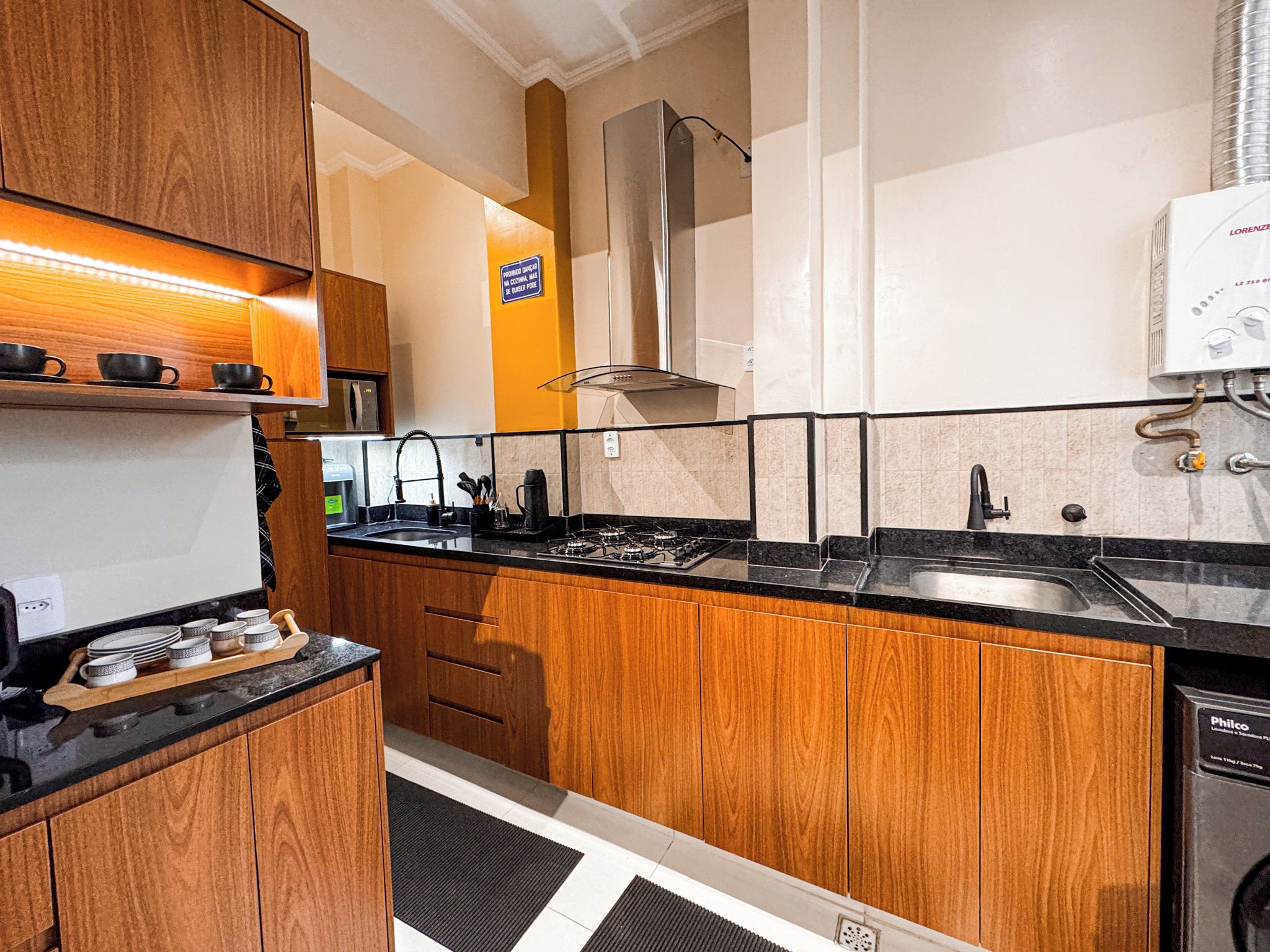 A compact kitchen with wooden cabinets, a gas stove, and a dishwasher.