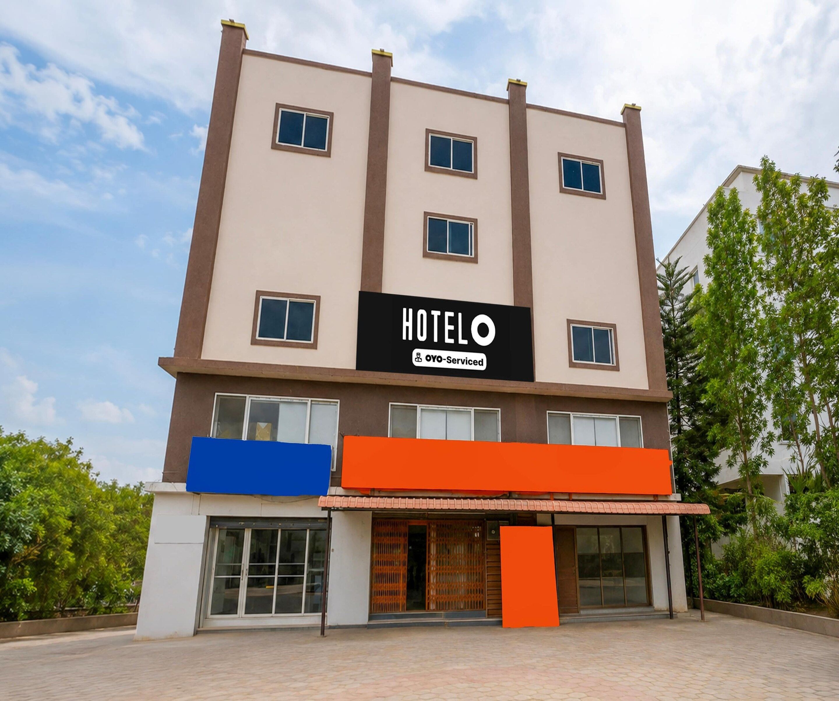 Un edificio di un hotel con un cartello che riporta 'HOTEL' e 'OYO-Serviced'.