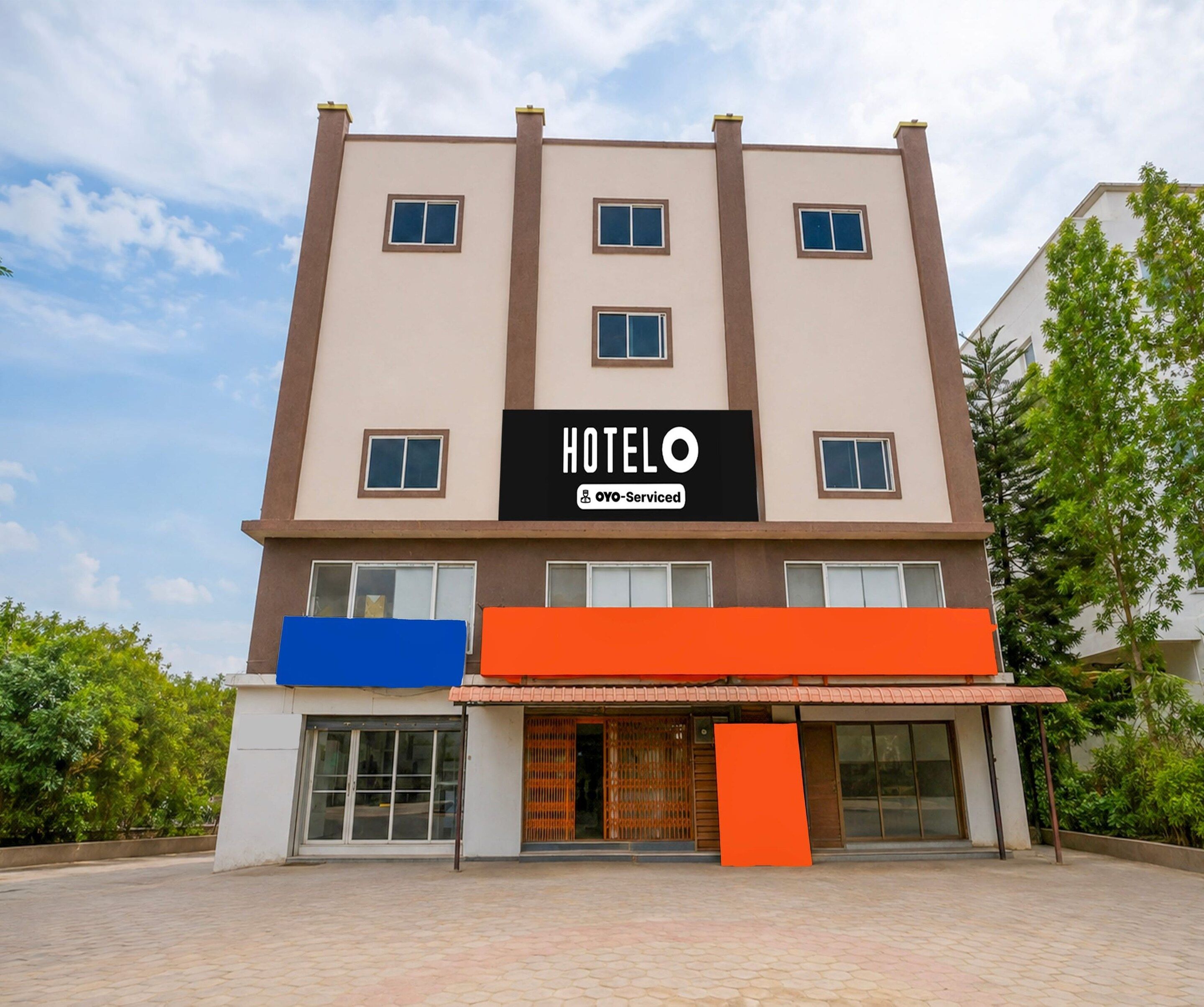 A hotel building with a sign indicating it is serviced by OYO.