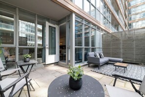 An outdoor patio with a sofa, chairs, and a table.