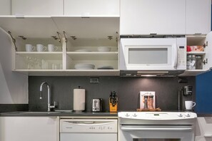 Eine kleine Küche mit Mikrowelle, Toaster und Kaffeemaschine.