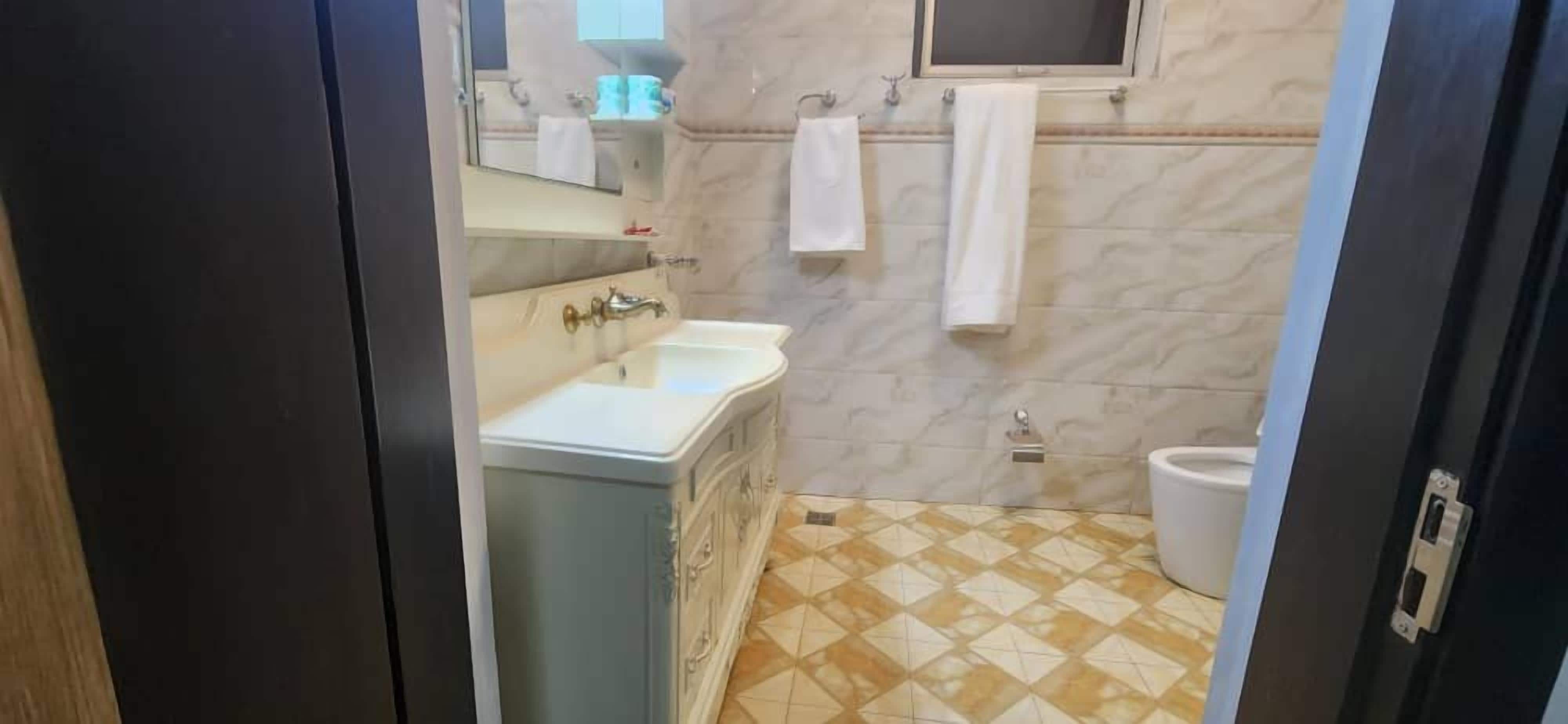A bathroom with a sink, mirror, and toilet.