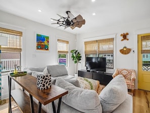 A living room with a sofa, a coffee table, a television, and a ceiling fan. - Coastal Home w/ Private Hot Tub, Block to Beach (Bethany Beach)