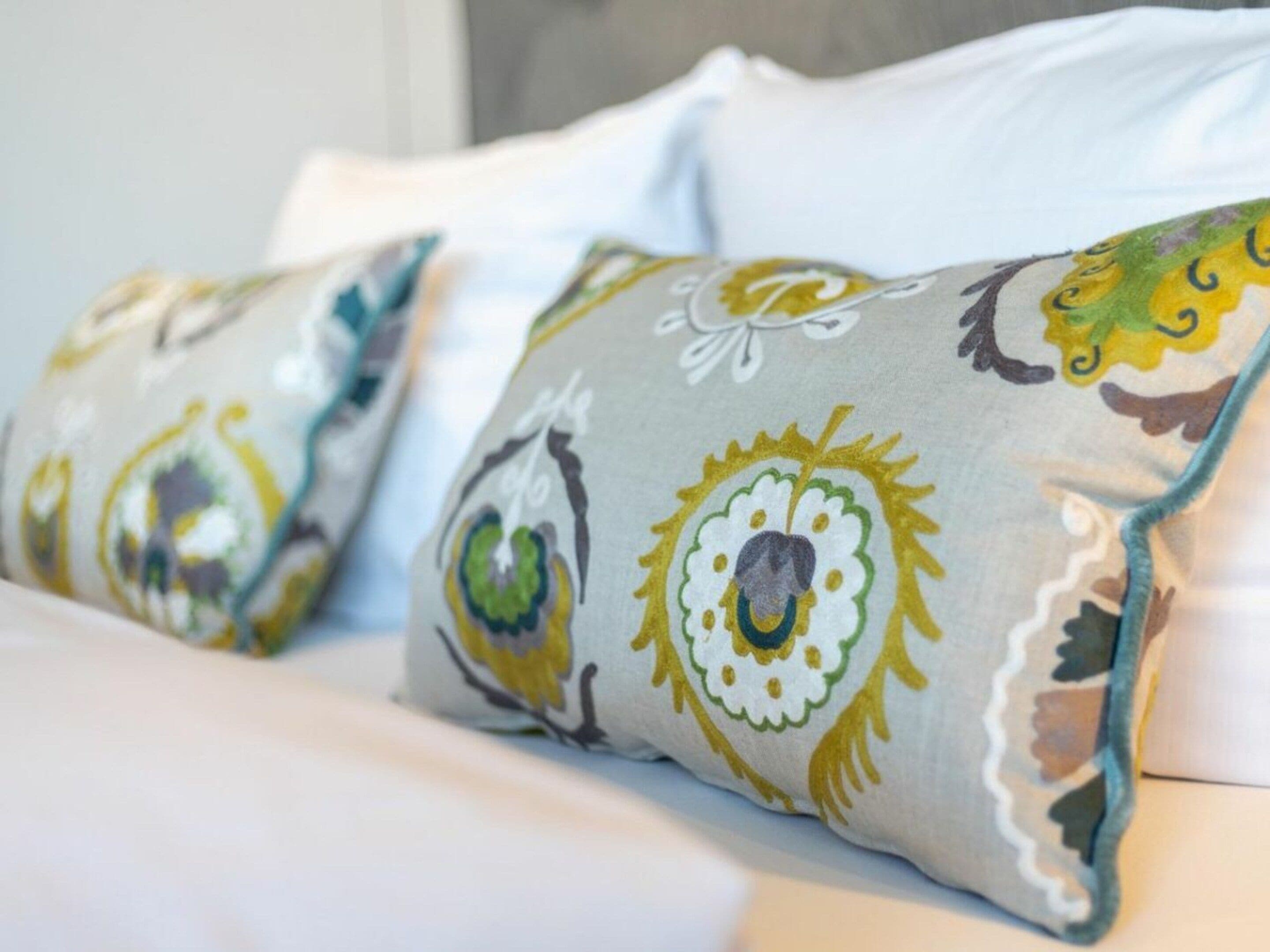 Un letto con cuscini decorati con un motivo floreale.