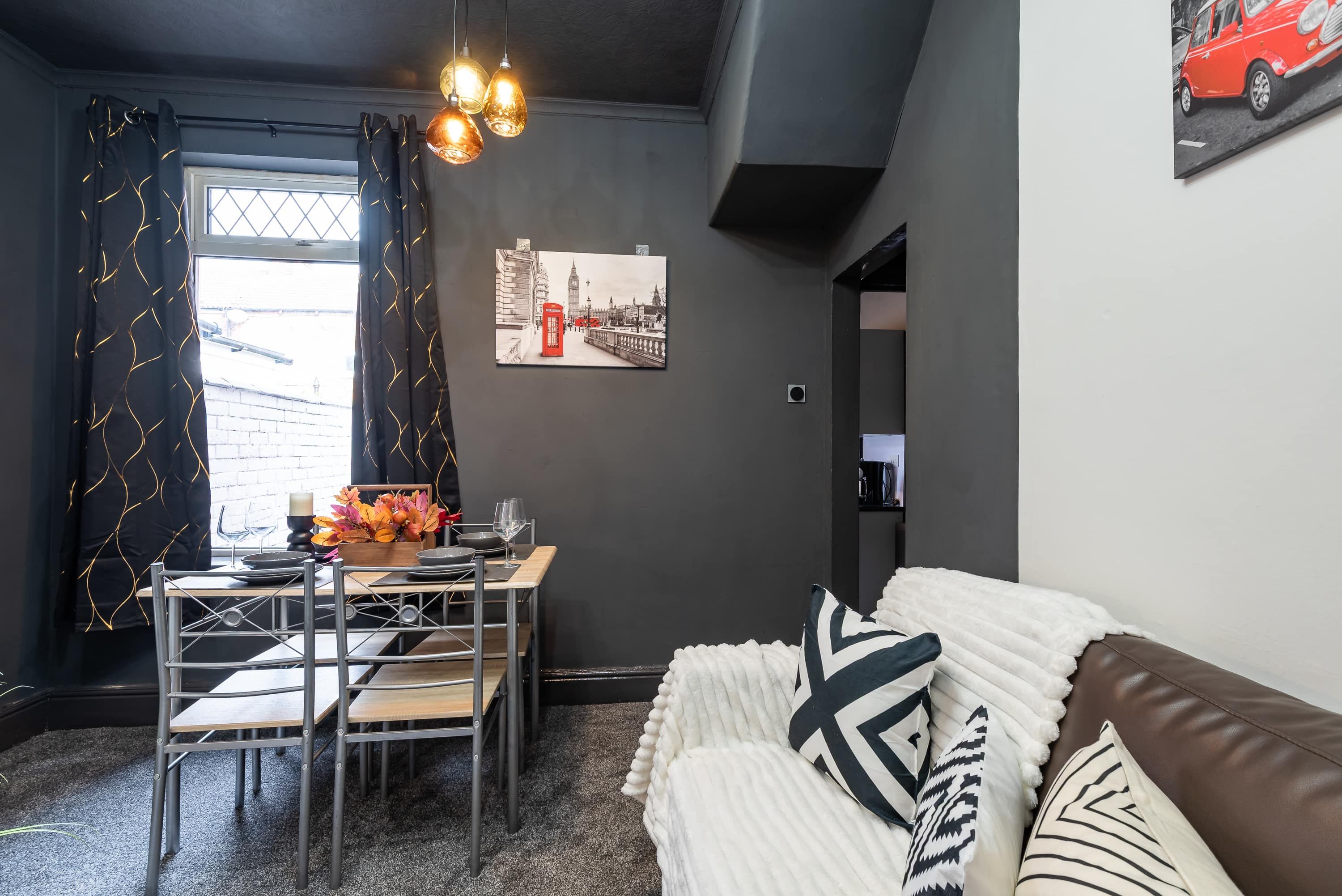 A modern living space with a dining area, a sofa, and a painting of a cityscape.