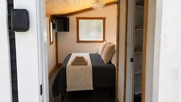 Une chambre à coucher comprenant un lit, une fenêtre, un placard et un luminaire au plafond.