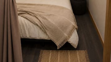 Un dormitorio con cama, mesita de noche, televisor y alfombra.