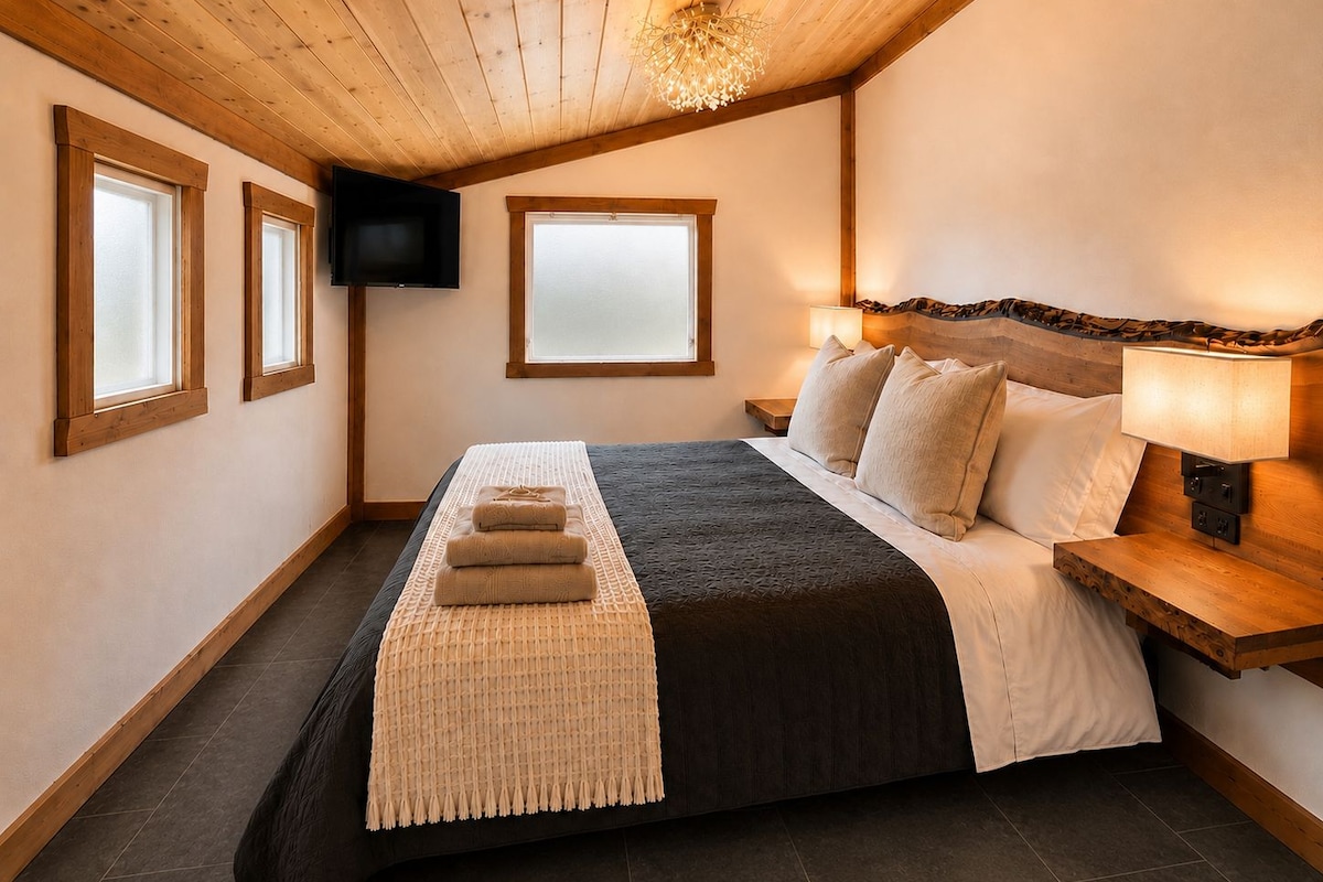 A bedroom with a bed, a TV, and a window.