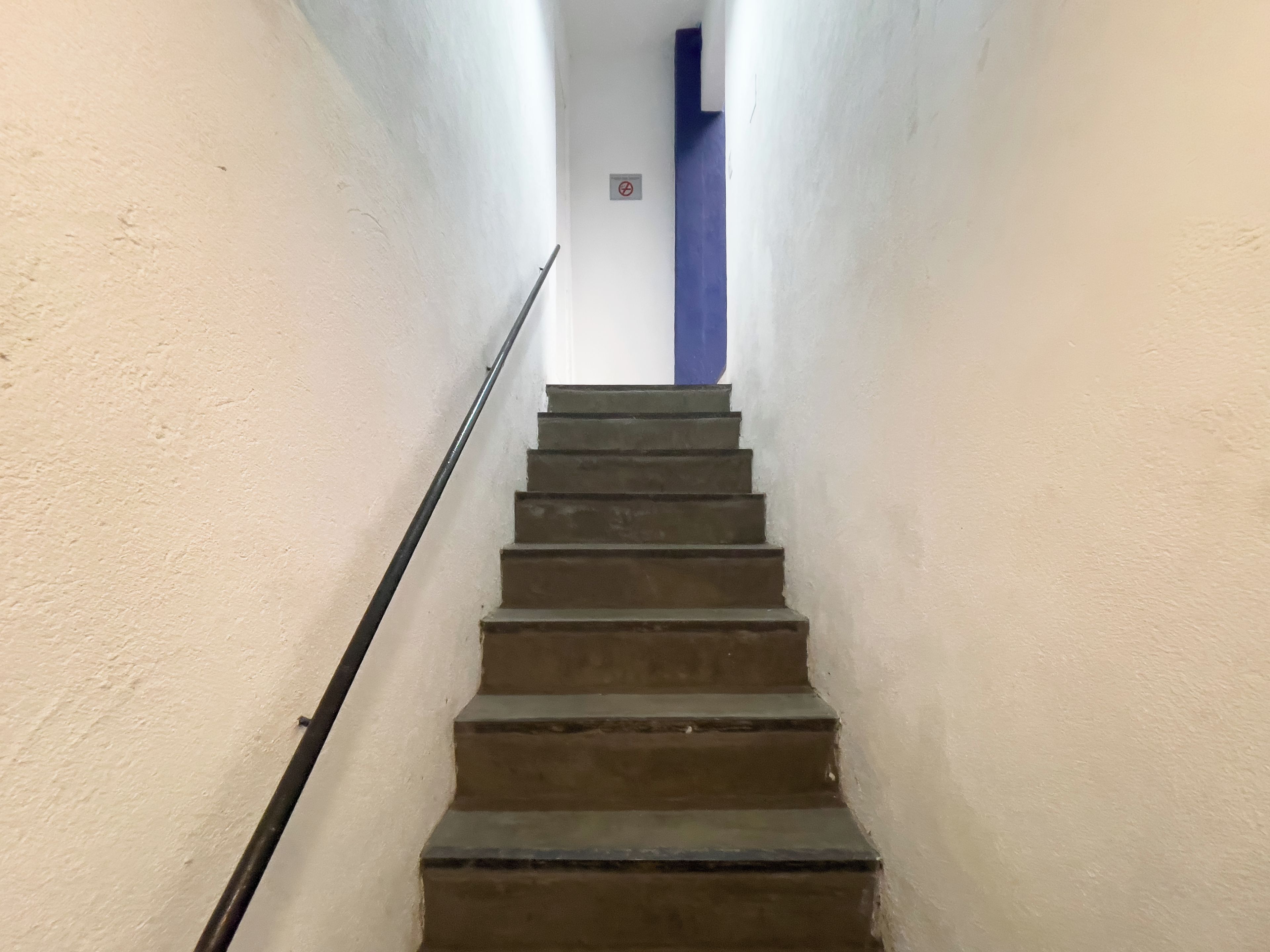 A staircase with a handrail leading to a landing.