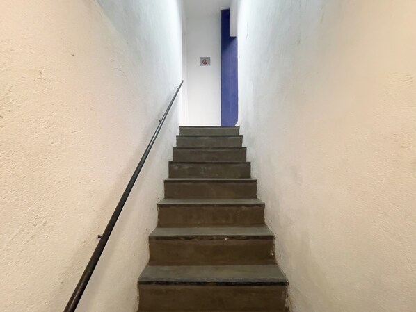 A staircase with a handrail leading to a landing.