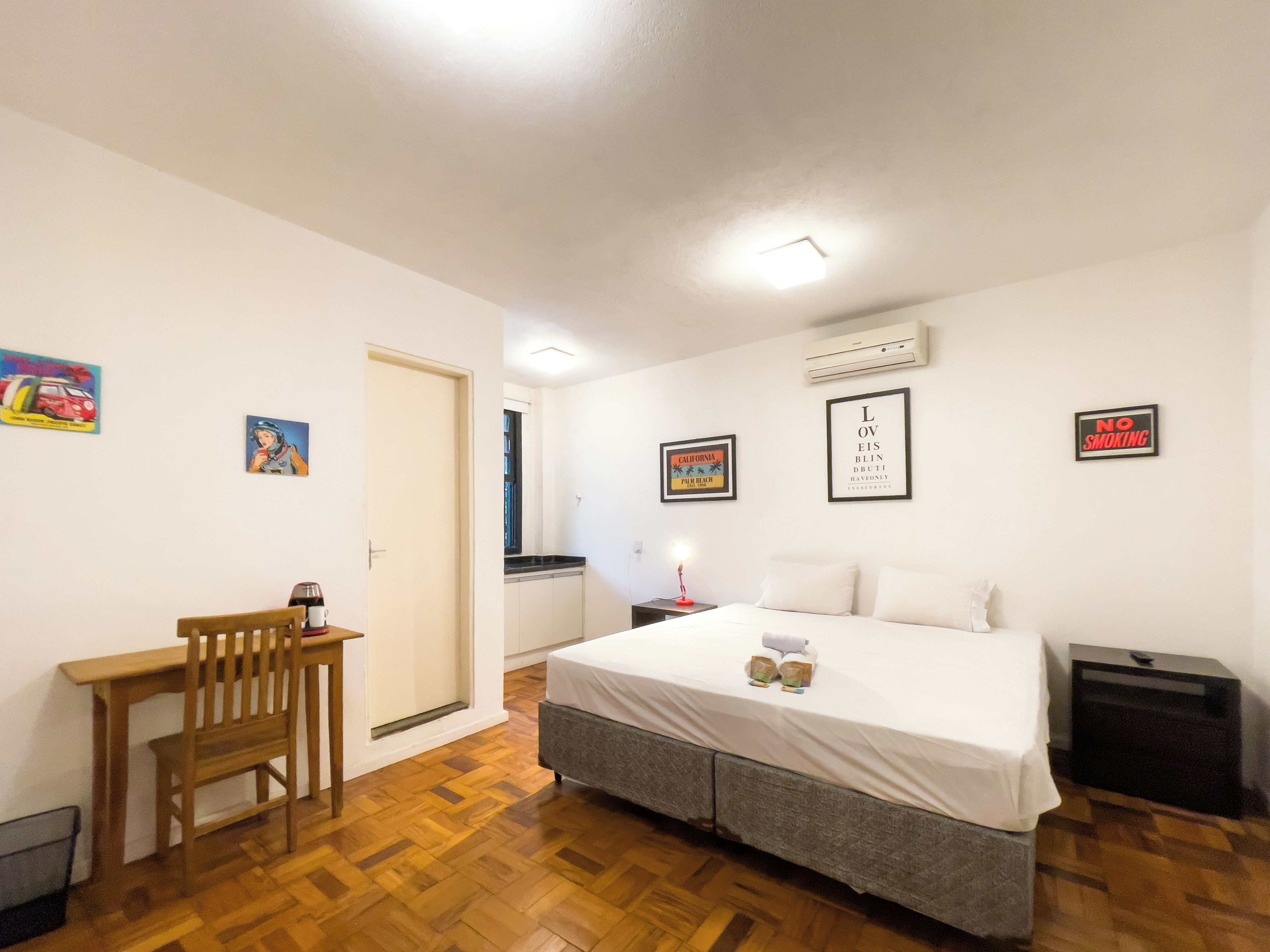 Ein Schlafzimmer mit einem Bett, einem Schreibtisch und einem Stuhl. An den Wänden befinden sich Dekorationen und es gibt ein Fenster.