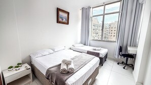 Una habitación de hotel con una cama grande, un escritorio y una ventana con cortinas.