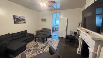 A living room with a sofa set, a coffee table, a TV, and a fireplace.