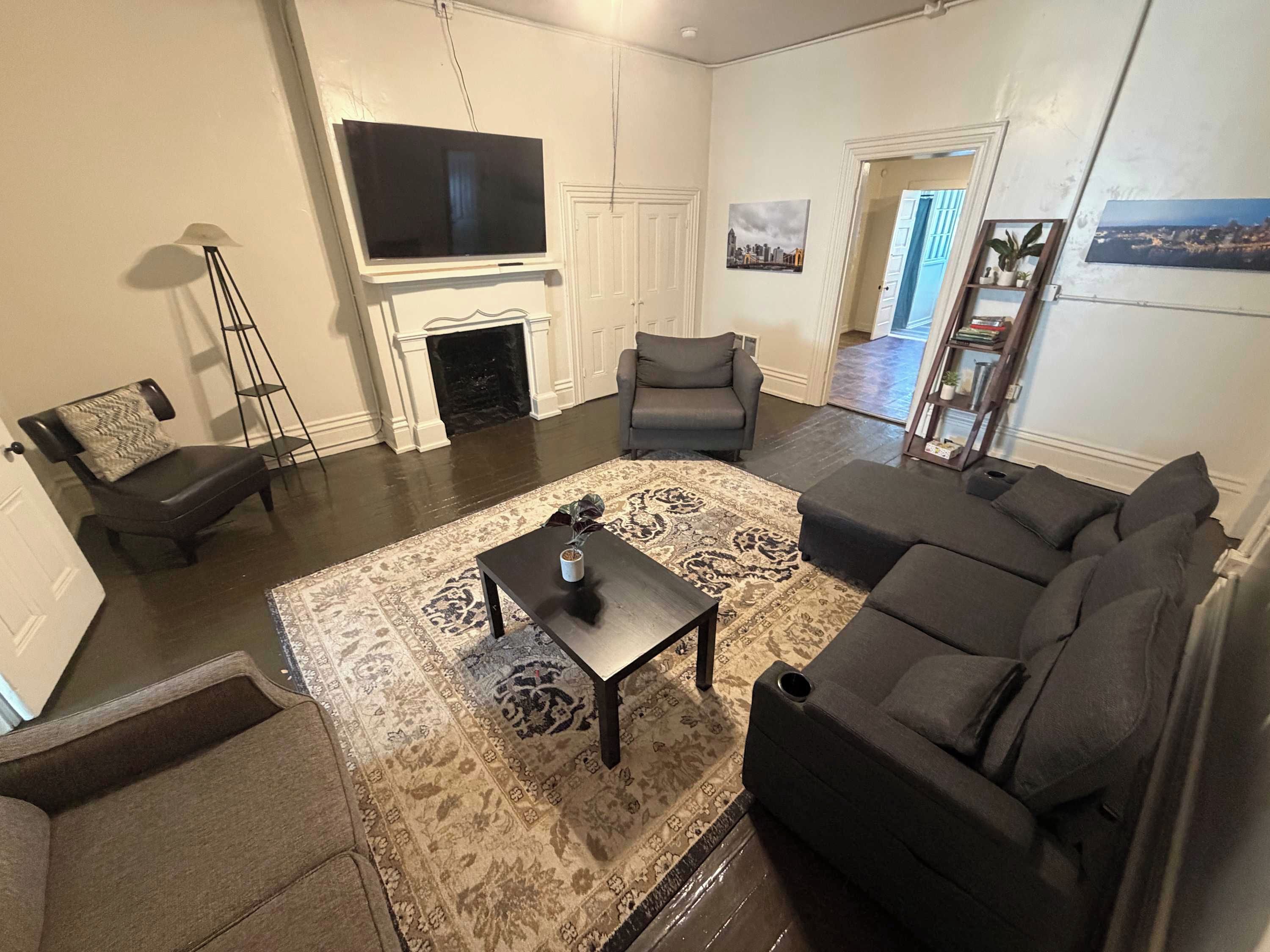 A living room with a fireplace, a television, and a sofa.