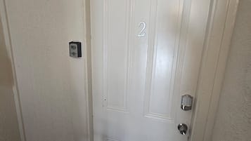 A white door with a number '2' on it, a doorbell, and a door handle.