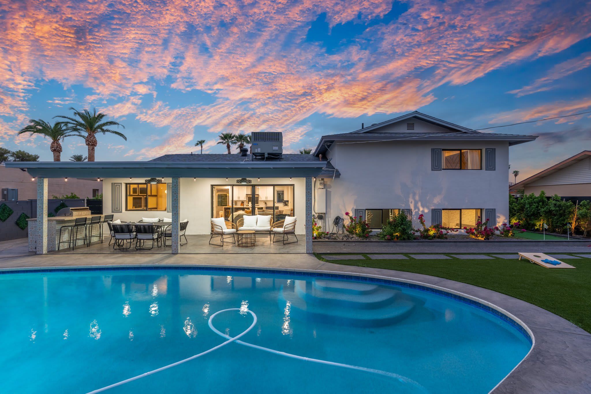 A residential property with a swimming pool, outdoor seating area, and a well-maintained garden.