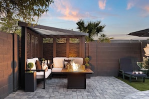 A patio area with a seating arrangement, a fire feature, and a view of the sea. - NEW| POSH Scottsdale |Speakeasy, Pool & Hot Tub (Scottsdale)