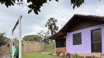 A house with a purple exterior, a wooden fence, and a grassy yard.
