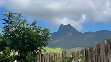 Paisaje montañoso con una valla de madera en primer plano y un cielo despejado.