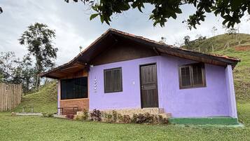 A small house with a sloped roof, a wooden porch, and a purple exterior.