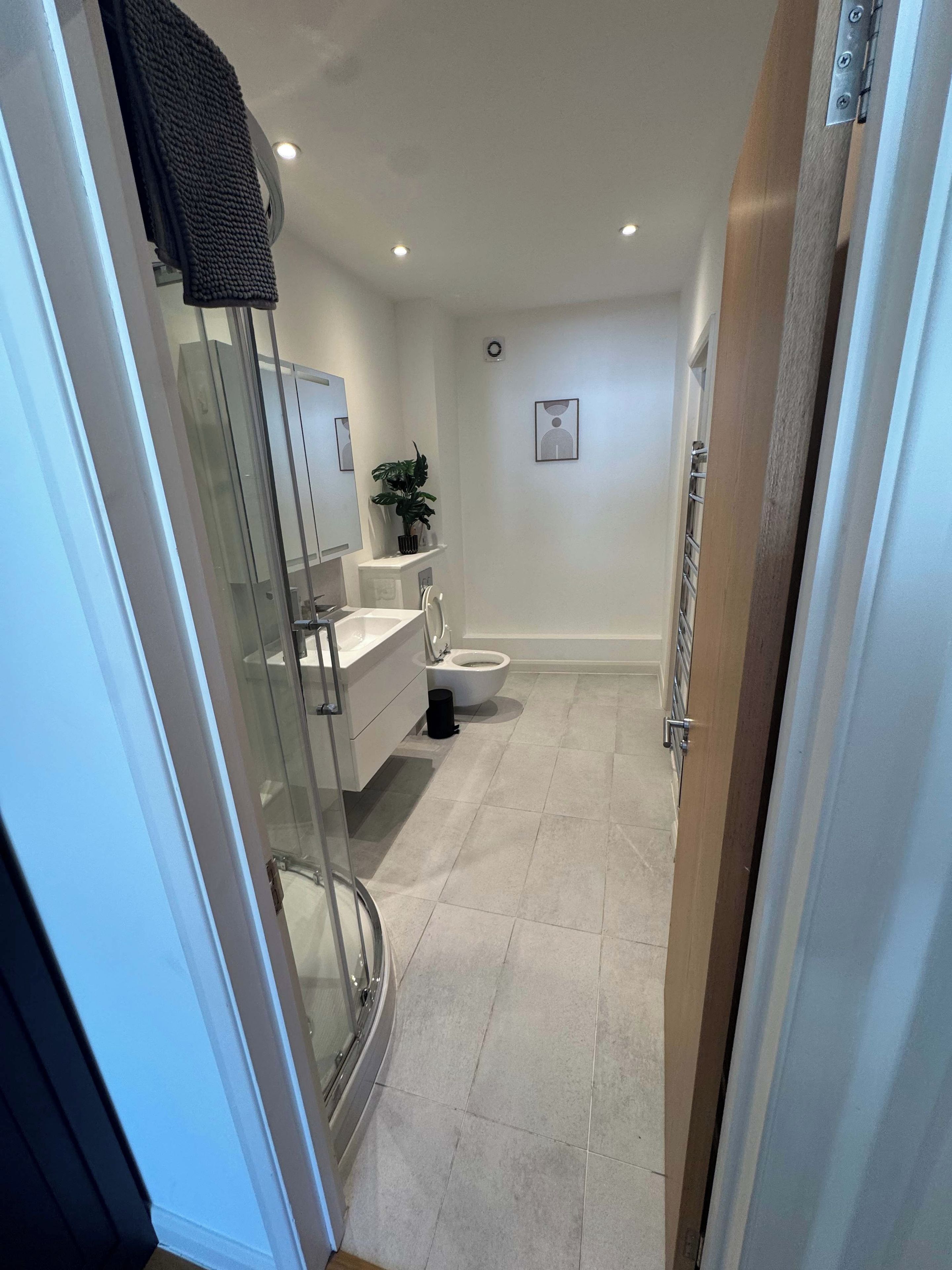Un bagno moderno con box doccia in vetro, un water e un lavabo.
