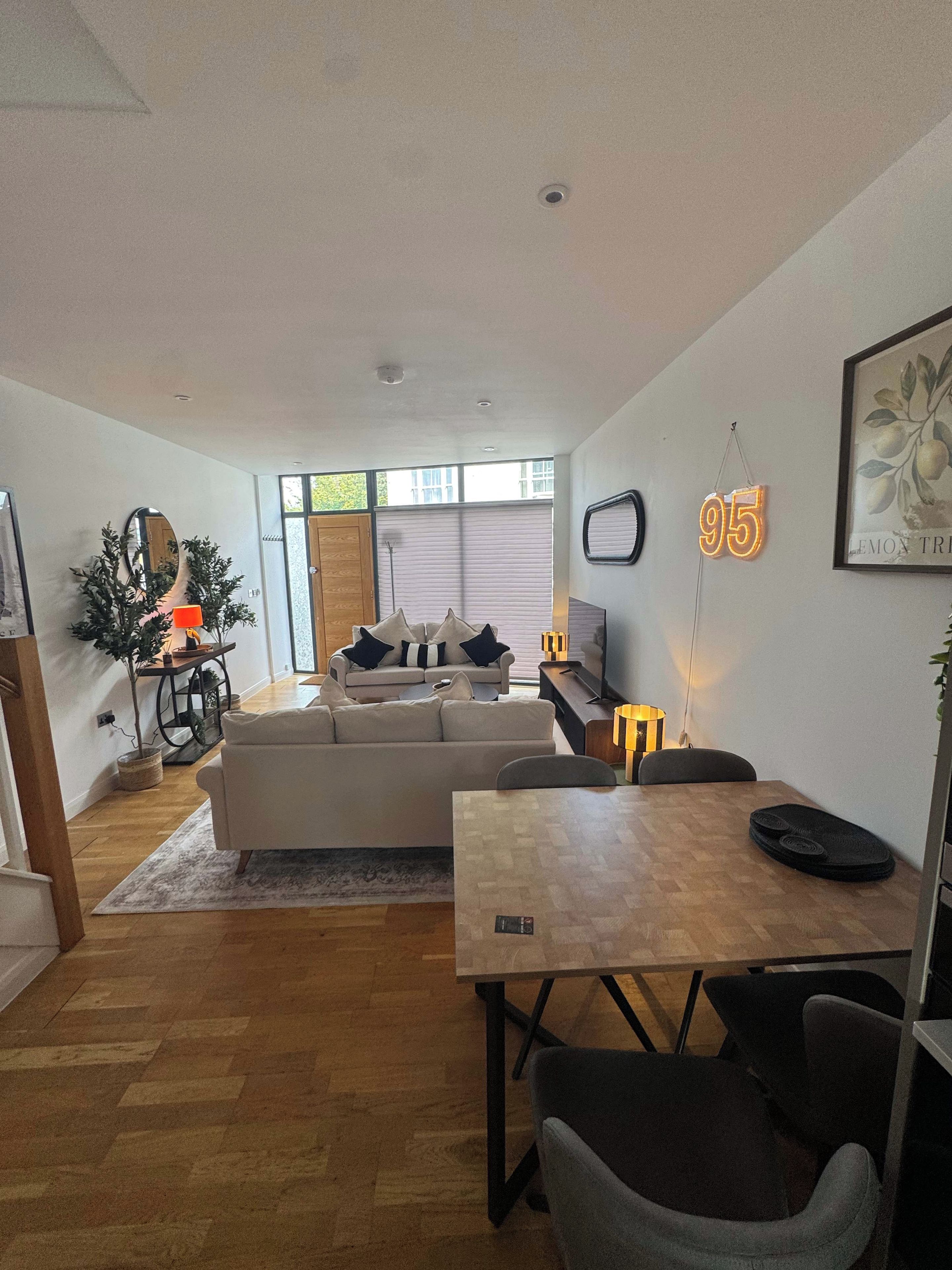 A modern living room with a sofa, a dining table, and a TV.
