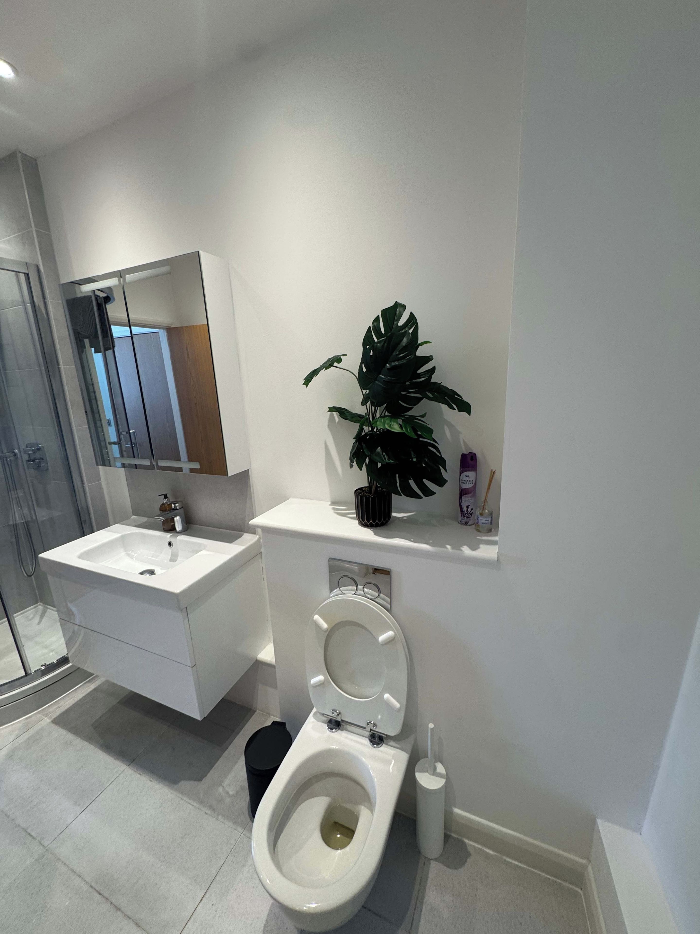 Un bagno moderno con toilette, lavandino e doccia.
