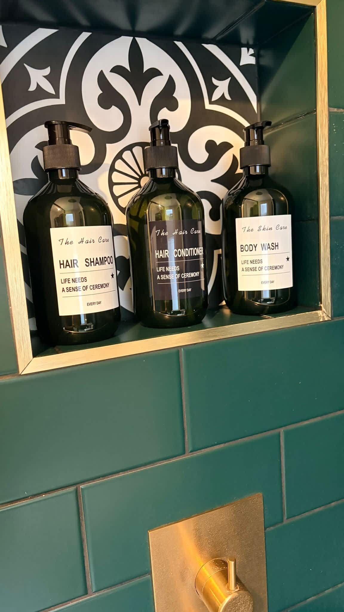 Uno scaffale con tre bottiglie di prodotti per la cura dei capelli.