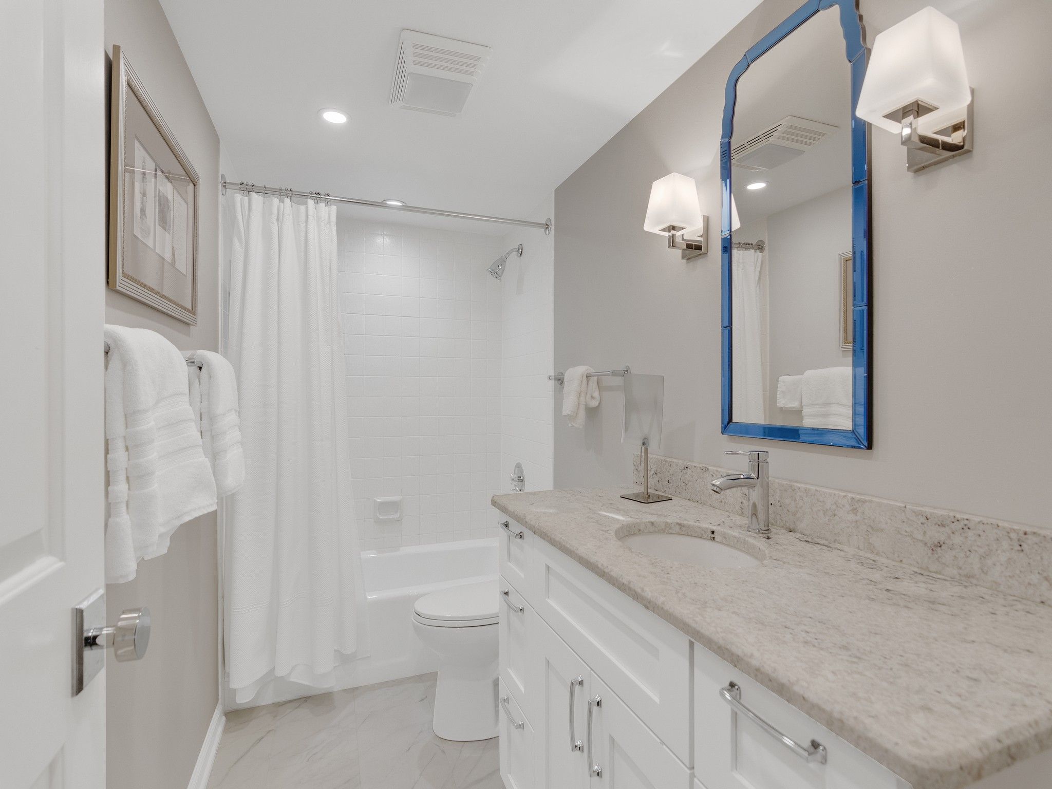 A modern bathroom with a bathtub, toilet, and vanity with a mirror.