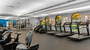 A gym with treadmills, weight machines, and exercise balls.