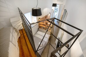 A bedroom with a bed, a wooden desk, and a window. - Residenza Scale Napoletane - Deluxe Triple Suite (Napoli)