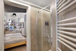 A modern bedroom with a bed, a walk-in closet, and a shower area. - Residenza Scale Napoletane - Deluxe Triple Suite (Napoli)