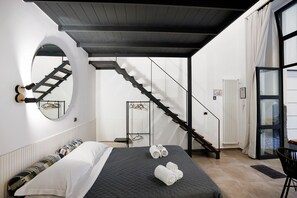 A bedroom with a bed, a circular mirror, a staircase, and a door leading to a balcony. - Residenza Scale Napoletane - Deluxe Quadruple Suite (Napoli)