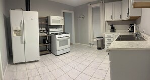 A kitchen with a refrigerator, microwave, stove, and sink. -  This cozy house places you just 5 minutes from all local businesses (Marshall)