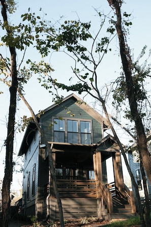A cabin with a steeply pitched roof, large windows, and a wooden porch.