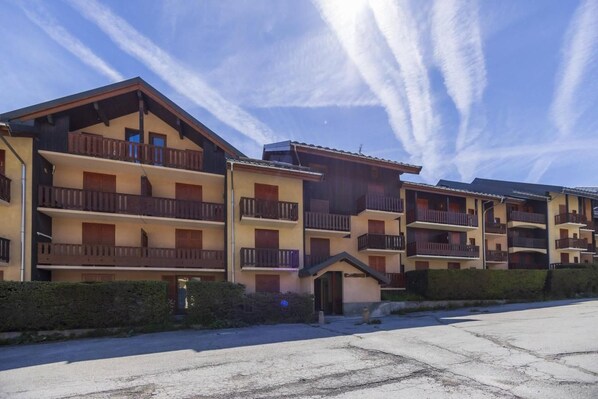 A multi-story building with balconies, a small entrance, and a parking area. - 350m from ski slopes, 3rd floor, balcony, parking, tv, ski locker, 36m², Valloire (Valloire)