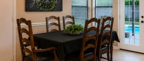Un comedor con una mesa, sillas y un adorno decorativo en la pared.