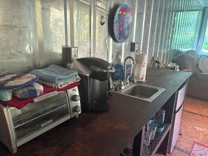 A kitchenette with a toaster, kettle, and sink.