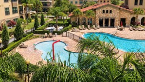 Un complex turístic amb piscina, gandules i un edifici de pedra.