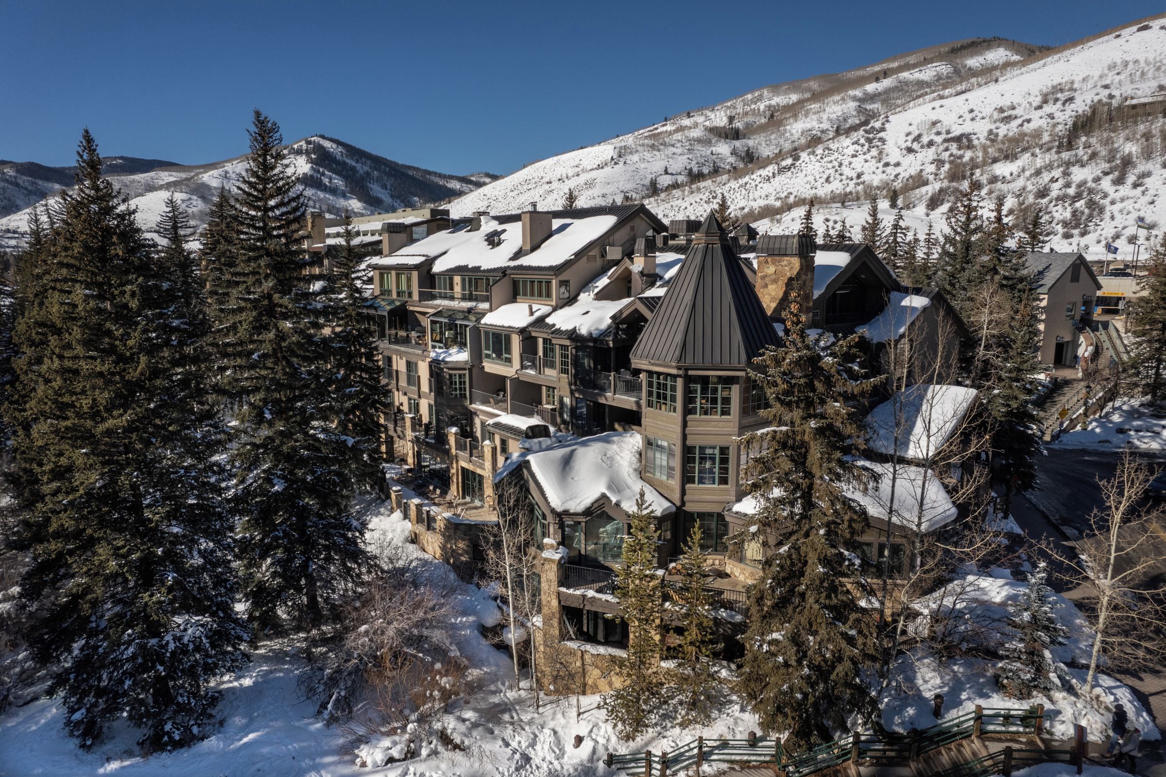 A snow-covered mountain resort with multiple buildings, including a prominent tower structure.